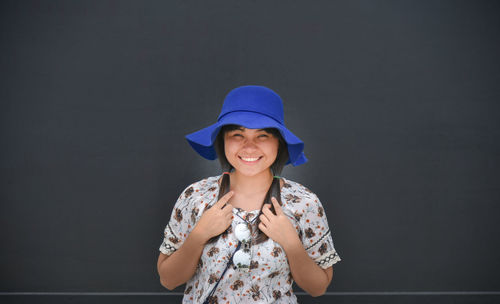 Portrait of young woman against billboard