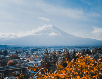 Aerial view of townscape and mountains against sky
