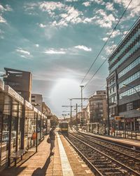 Railroad tracks amidst buildings in city against sky