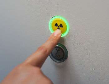 Close-up of hand pressing radioactive warning symbol button 