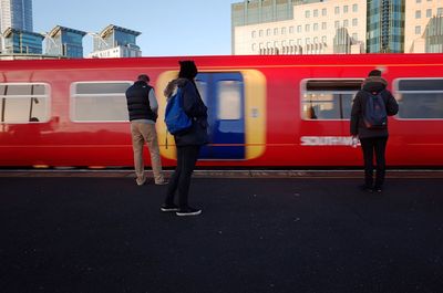 Full length of red train in city