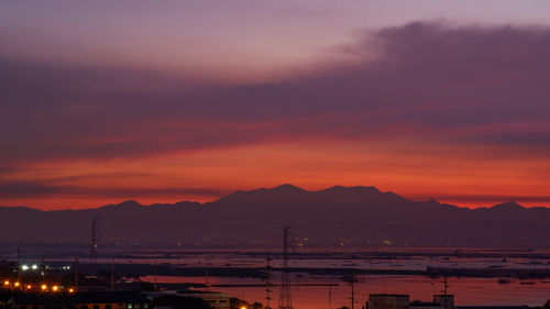 Silhouette mountains against orange sky