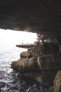 Rock formation on beach against sky