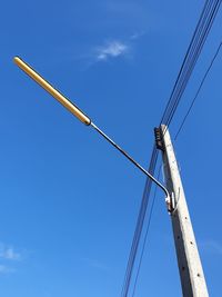 Low angle view of cranes against blue sky