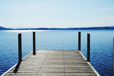 Wooden pier over sea against sky