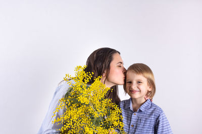 Portrait of mother and son on flower against clear sky