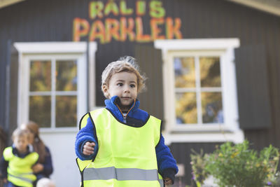 Boy in protective jacket outside preschool building