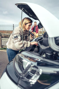 Woman repairing broken down campervan