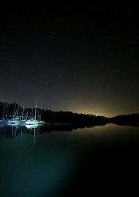 Scenic view of lake against clear sky at night