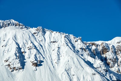 Scenic view of snowcapped mountains against clear blue sky