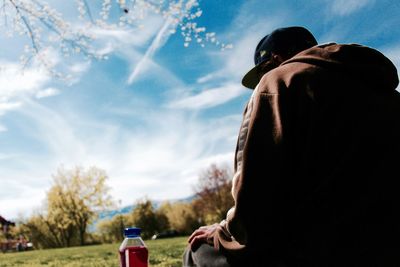 Rear view of man sitting against sky