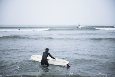 Woman going surfing during winter snow