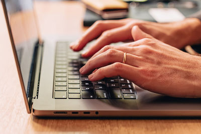 Close-up of male hands typing on the laptop keyboard