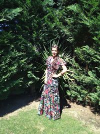 Portrait of a young woman standing on tree