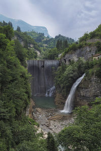 Scenic view of waterfall against sky