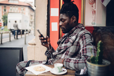 Man holding food while sitting on table