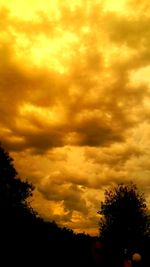 Silhouette of trees against cloudy sky