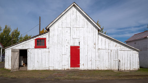 Exterior of barn outside house against sky