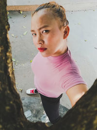 Portrait of woman standing on footpath