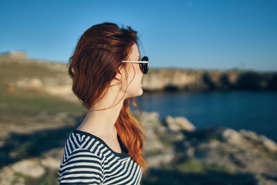 Portrait of woman wearing sunglasses against sky