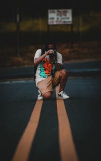 Full length of woman sitting on street