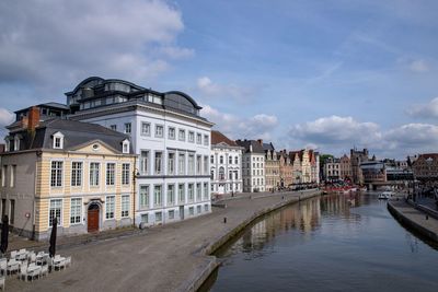 Canal amidst buildings in town against sky