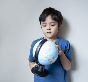 Cute boy standing against white background