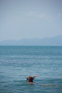 Woman snorkeling in sea against sky