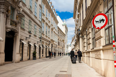 People on road amidst buildings in city