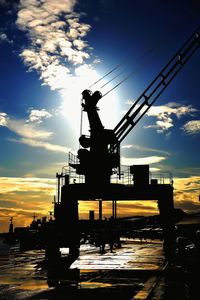 Low angle view of crane against sky at sunset