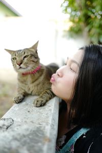 Close-up of woman siting with cat outdoors