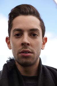 Close-up portrait of young man against sky