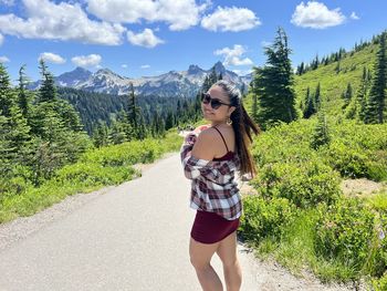 Portrait of young woman standing against mountain