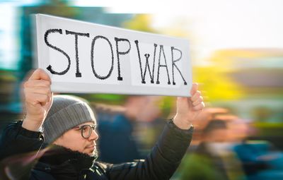 Protestor holding banner at anti-war rally