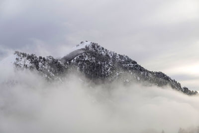 Low angle view of snow covered mountain against sky