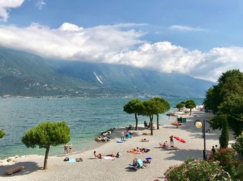 Group of people on beach against sky