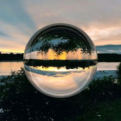 Reflection of trees on lake against sky during sunset