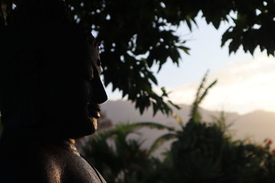 Close-up portrait of silhouette man looking away against sky