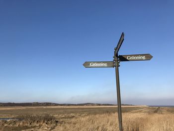 Information sign on field against clear sky