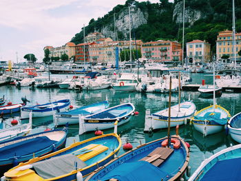 Boats moored at harbor against sky