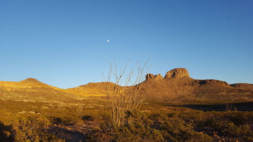 Scenic view of desert mountains against clear blue sky