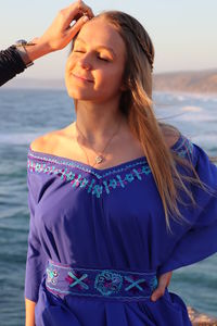 Beautiful young woman standing at beach