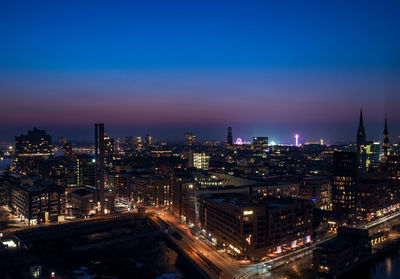 High angle view of illuminated buildings against sky at night