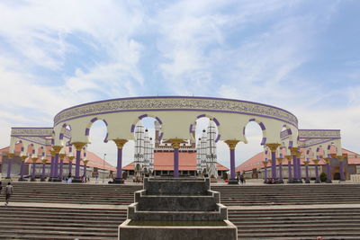 Low angle view of amusement park against cloudy sky