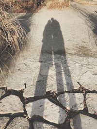 Shadow of people standing on cobblestone