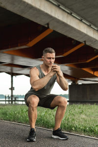 Full length of young man exercising on field