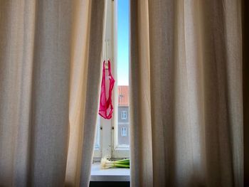 Close-up of clothes drying against window at home