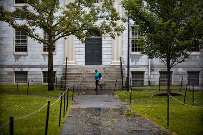 Rear view of man walking by building