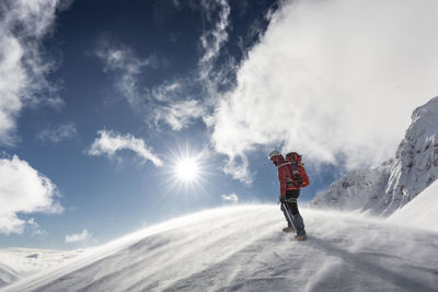 Rear view of man standing on snow covered mountain