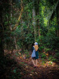 Rear view of woman walking in forest